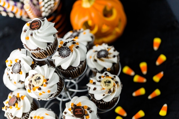 Cupcakes de chocolate para Halloween con glaseado de crema de mantequilla blanca y virutas de chocolate encima.