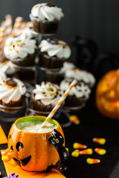 Cupcakes de chocolate para Halloween con glaseado de crema de mantequilla blanca y virutas de chocolate encima.