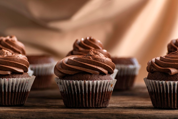 Cupcakes de chocolate con tapas de crema de mantequilla sobre mesa de madera. Deliciosos muffins de chocolate de cerca.