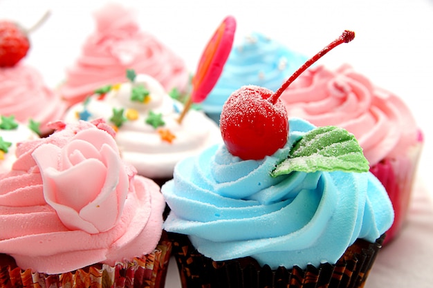 cupcakes coloridos com cobertura rosa e granulado