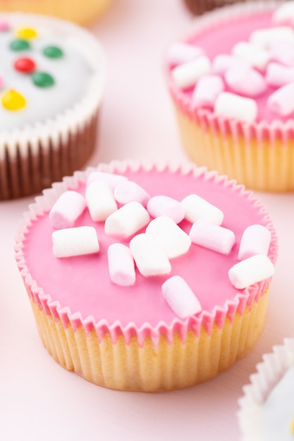 Cupcakes coloridos em uma rosa.