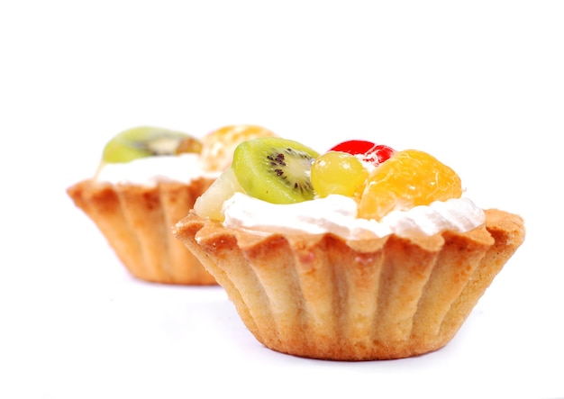 Cupcakes com creme e frutas no fundo branco