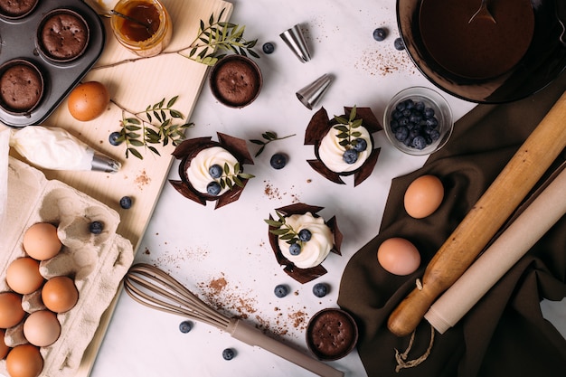 Cupcakes com creme e mirtilos na mesa da cozinha