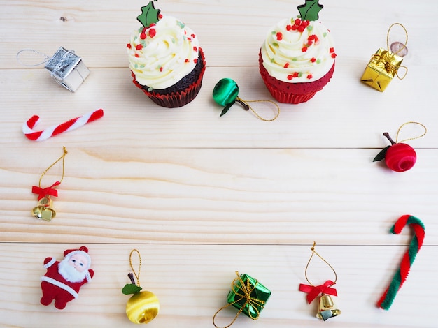 Cupcakes com decoração de forma e ornamento de natal na mesa de madeira