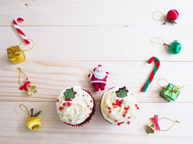 Cupcakes com decoração de forma e ornamento de Natal na mesa de madeira