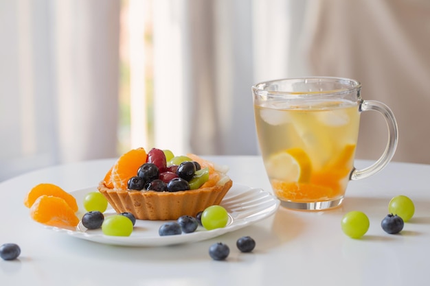 cupcakes com frutas e bebida gelada e saudável na mesa branca