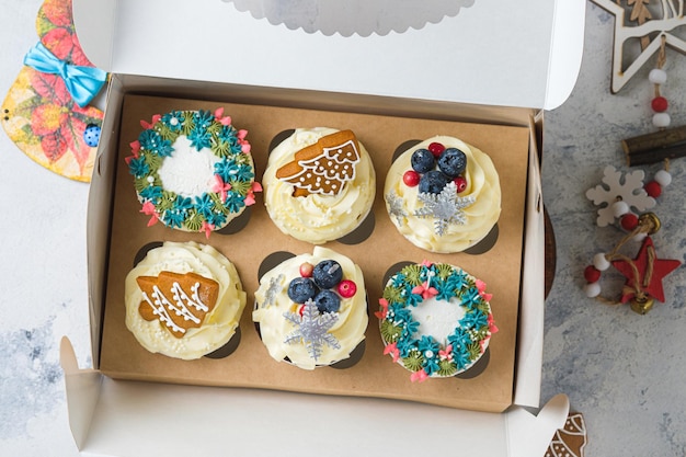 Cupcakes con crema de queso crema y relleno de caramelo de maní. Juegos de postres de regalo de Navidad. Tortas en la decoración de Año Nuevo.