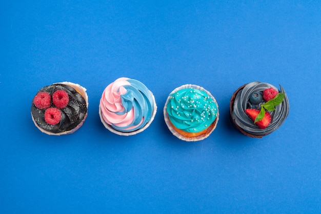 Cupcakes de cumpleaños sobre fondo azul de cerca