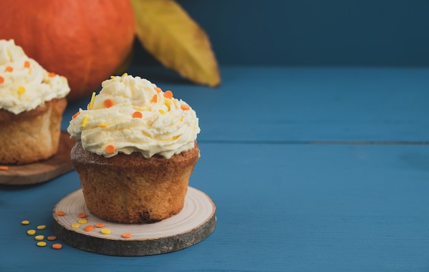 Cupcakes de abóbora com chantilly na mesa de madeira azul