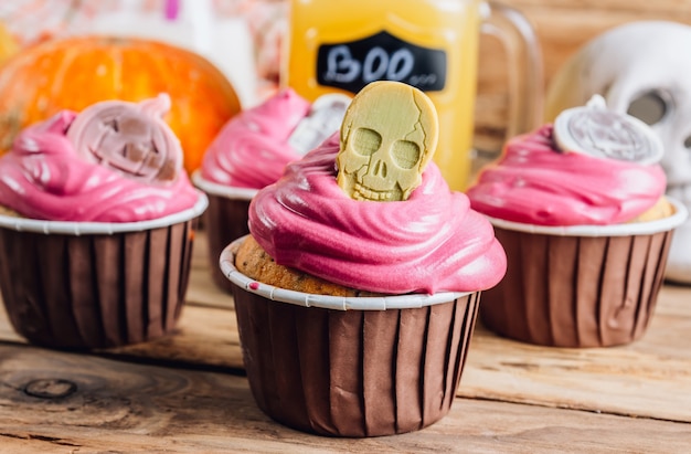 Cupcakes de abóbora de Halloween decorados com creme rosa