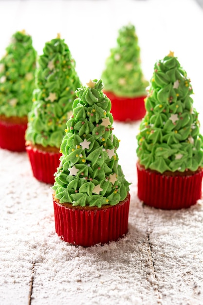 Cupcakes de árvore de natal na mesa de madeira