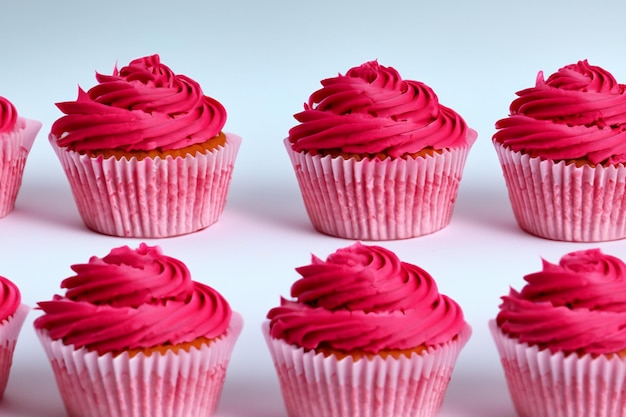 Cupcakes de chocolate com cobertura rosa isolado em um fundo branco