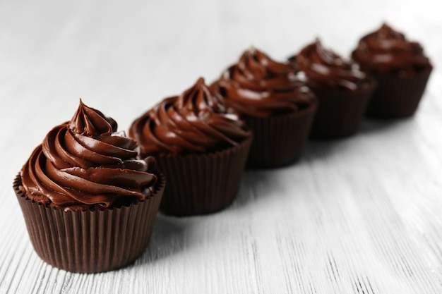 Cupcakes de chocolate na luz de fundo de madeira