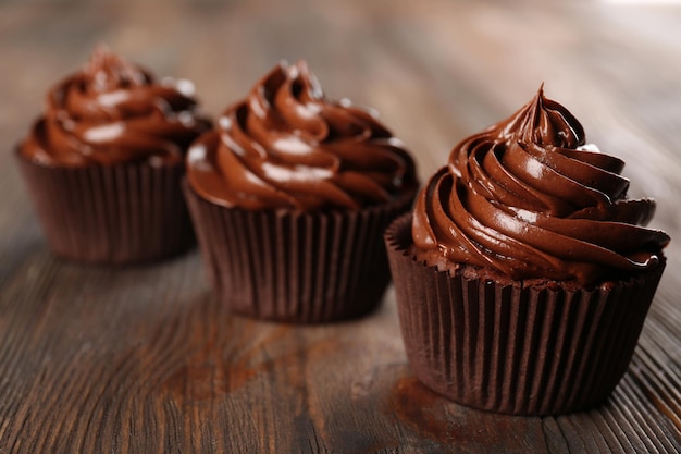 Cupcakes de chocolate no fundo escuro de madeira