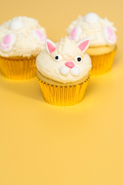 Cupcakes de coelhinho da páscoa em fundo amarelo.