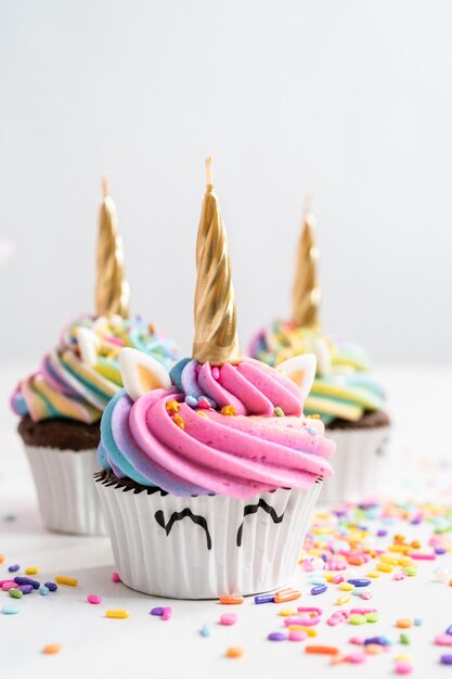 Cupcakes de unicórnio decorados com cobertura de buttercream colorida e granulado.