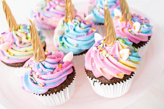 Cupcakes de unicórnio decorados com cobertura de buttercream colorida e granulado.