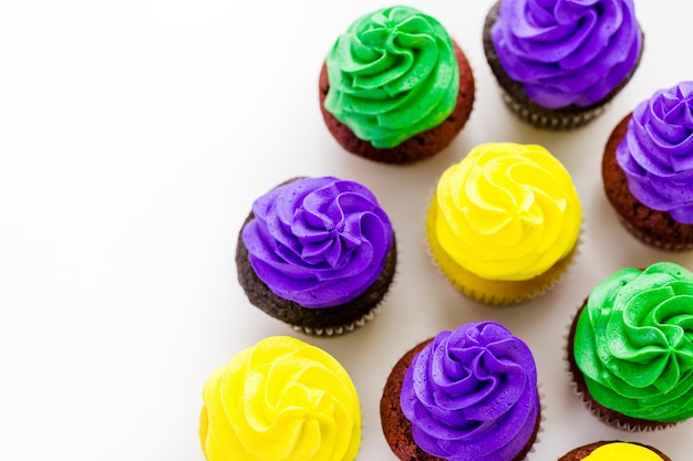 Cupcakes decorados com glacê de cores brilhantes para a festa de Mardi Gras.