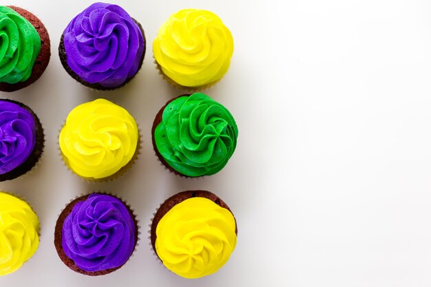 Cupcakes decorados com glacê de cores brilhantes para a festa de Mardi Gras.