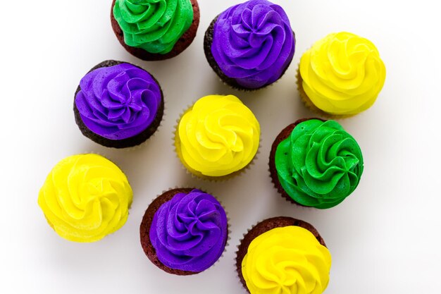 Cupcakes decorados com glacê de cores brilhantes para a festa de Mardi Gras.