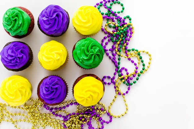 Cupcakes decorados com glacê de cores brilhantes para a festa de Mardi Gras.