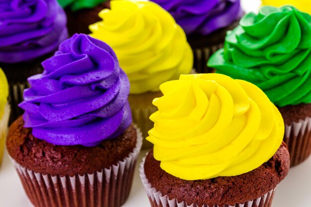 Cupcakes decorados com glacê de cores brilhantes para a festa de Mardi Gras.