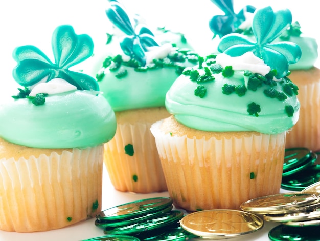 Cupcakes decorados em um ambiente festivo do dia de São Patrício com trevos.