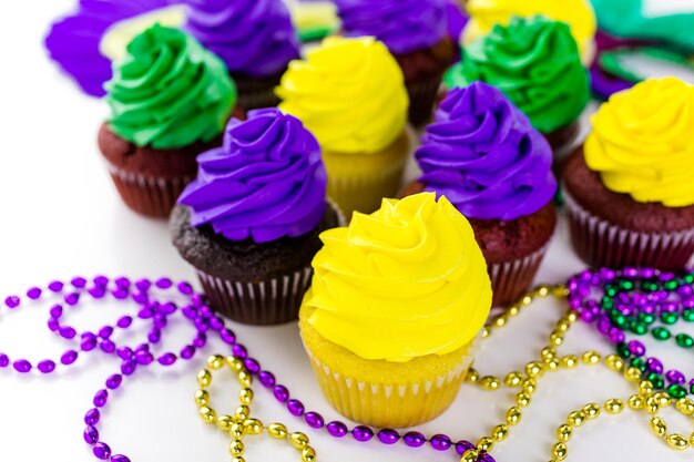 Cupcakes decorados con glaseado de colores brillantes para la fiesta de Mardi Gras.