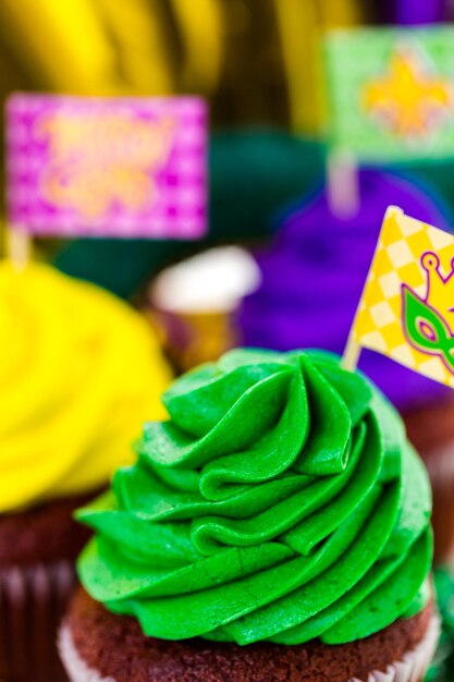 Cupcakes decorados con glaseado de colores brillantes para la fiesta de Mardi Gras.