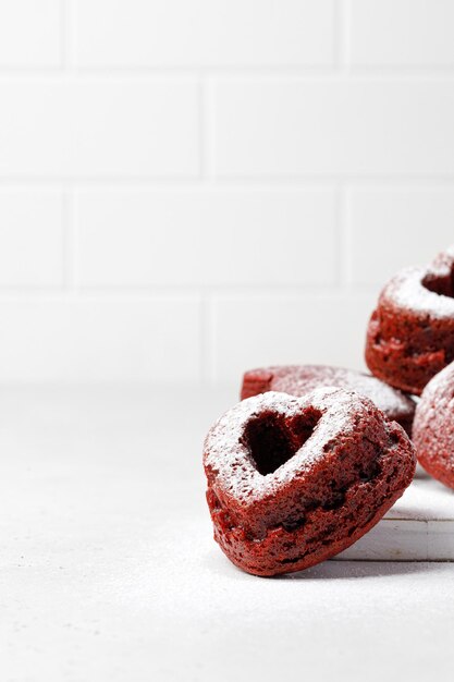 Cupcakes em forma de coração, muffins de veludo vermelho com açúcar de confeiteiro. conceito e ideia de dia dos namorados