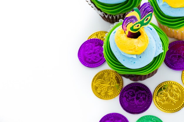 Cupcakes de fantasía decorados con hoja y máscara para fiesta de Mardi Gras.