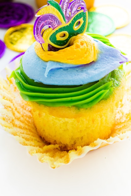 Cupcakes de fantasía decorados con hoja y máscara para fiesta de Mardi Gras.