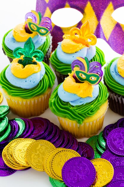 Cupcakes de fantasía decorados con hoja y máscara para fiesta de Mardi Gras.