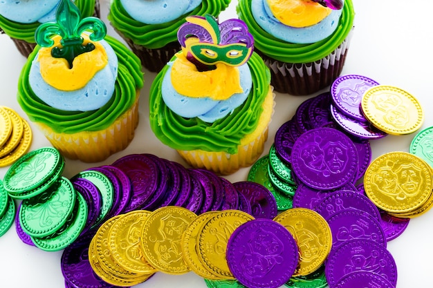 Cupcakes de fantasía decorados con hoja y máscara para fiesta de Mardi Gras.