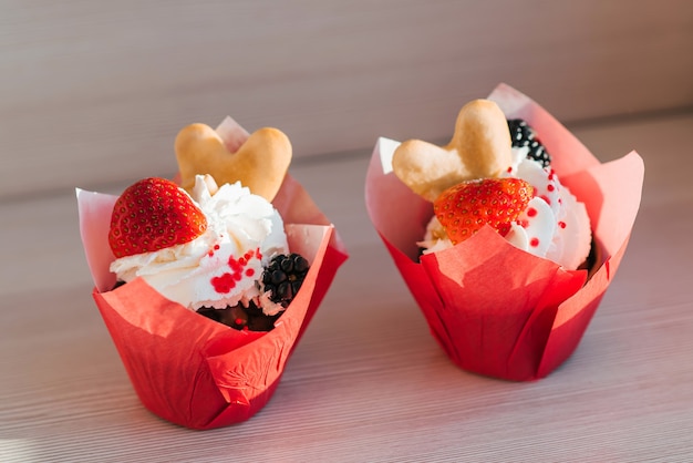 Cupcakes festivos con crema y fresas frescas y moras