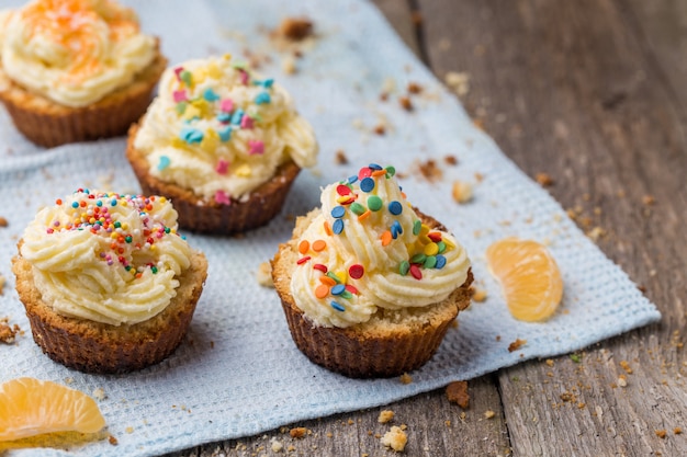 Cupcakes con glaseado blanco y sprinkles.