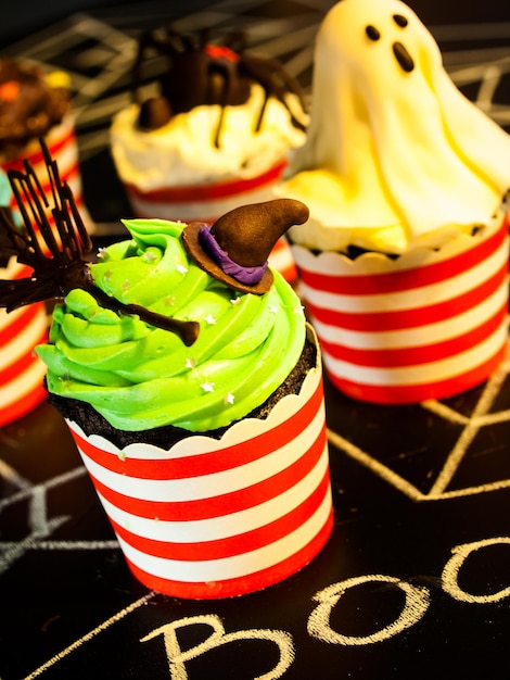 Cupcakes gourmet de Halloween com fundo preto de decoração de férias.