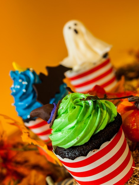 Cupcakes gourmet de Halloween con decoración navideña de fondo naranja.