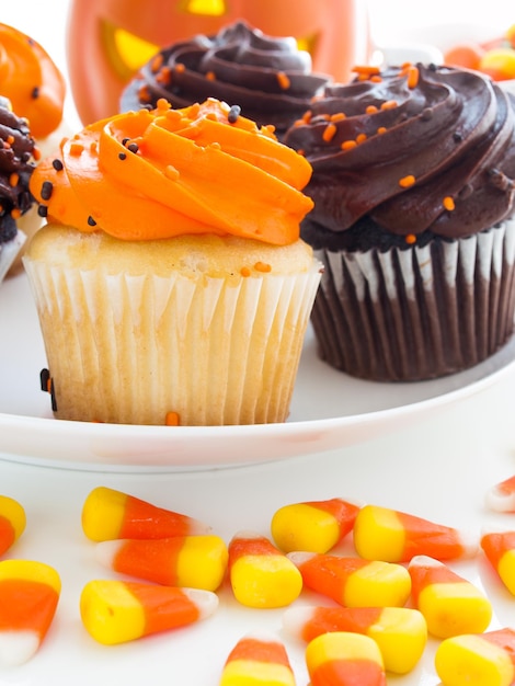 Cupcakes de Halloween con glaseado de naranja y negro en un plato blanco.