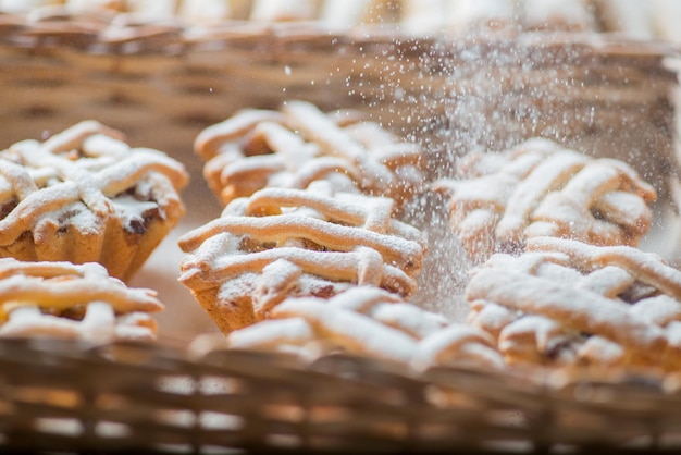 Cupcakes in einem Korb werden mit Puderzucker zerkleinert