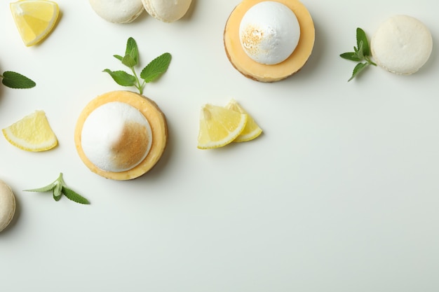 Cupcakes, macaroons e ingredientes de limão em fundo branco