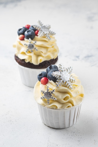 Cupcakes mit Frischkäsecreme und Erdnuss-Karamell-Füllung. Weihnachtsgeschenksets mit Desserts. Kuchen im Neujahrsdekor.