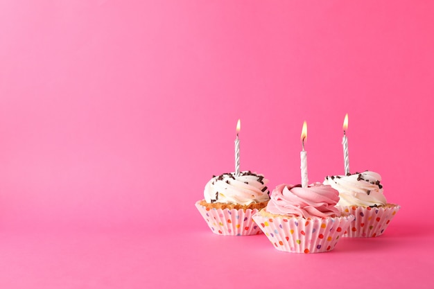 Cupcakes mit Kerze auf rosa Hintergrund, Platz für Text