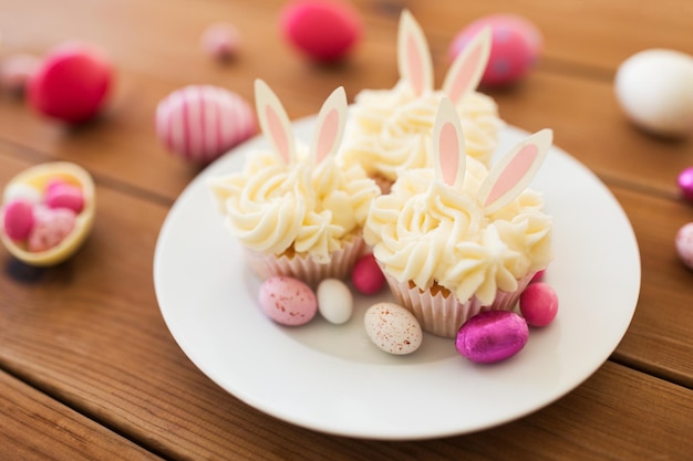 Cupcakes mit Ostereiern und Süßigkeiten auf dem Tisch