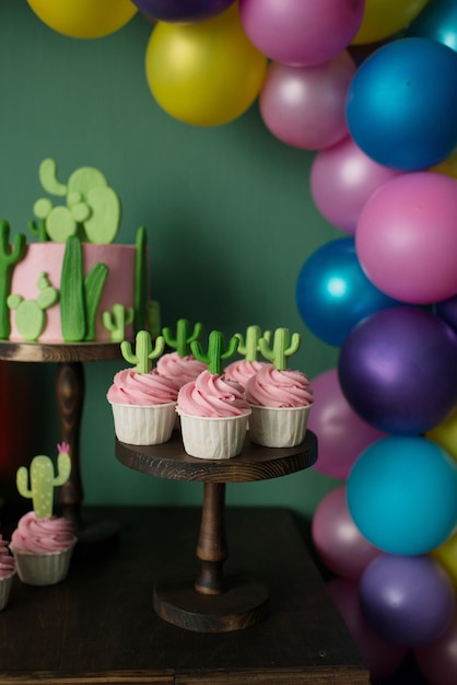 Cupcakes mit rosa Creme mit Kakteen verziert. Sommersüßer Geburtstagstisch.