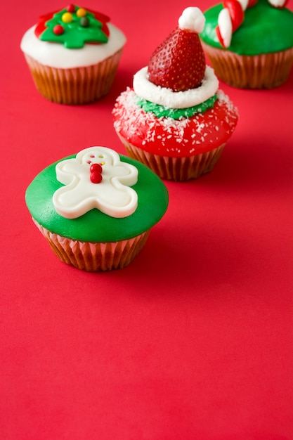 Cupcakes de Navidad sobre fondo rojo.