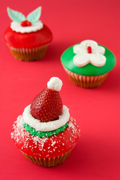 Cupcakes de Navidad sobre fondo rojo.