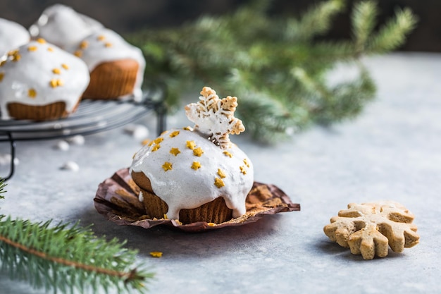 Cupcakes navideños. Postre de Navidad con gotas de chocolate y malvavisco. Fondo de madera con decoración navideña y ramas de abeto.