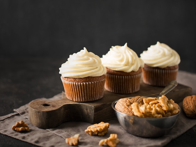 Cupcakes ou muffins de cenoura com nozes no preto