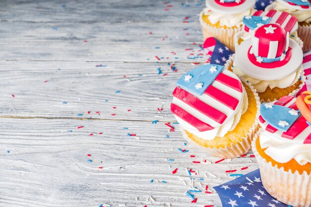 Cupcakes patrióticos dos EUA sobre bandeiras na mesa de madeira